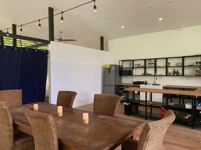 a dining room with a wooden table and chairs at Awarded No Footprint House on Matapalo Beach in Savegre
