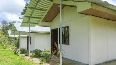 a white house with a porch at Rio Celeste Cabinas Vista Tenorio in El pilon