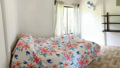 a bedroom with a bed with a floral blanket at Ibis House, Bijagua in Upala