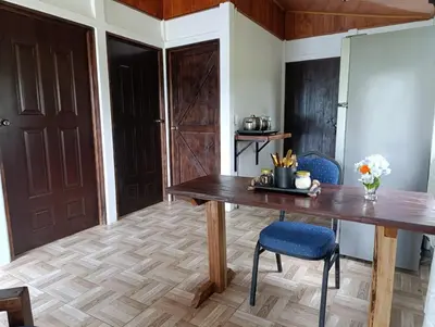 a dining room with a wooden table and chairs at Ibis House, Bijagua in Upala