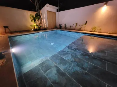 an empty swimming pool in a house at night at Casa joy costa rica in Mal País