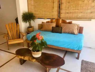 a bedroom with a bed and a table with a potted plant at Casa joy costa rica in Mal País