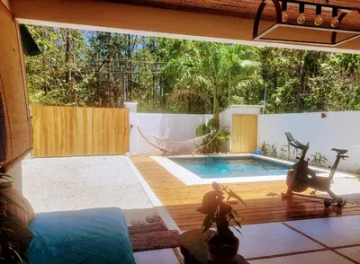 a backyard with a swimming pool and a hammock at Casa joy costa rica in Mal País