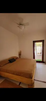 a bedroom with a bed with a ceiling fan at Casa joy costa rica in Mal País