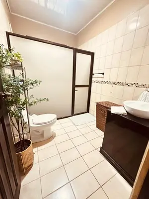 a bathroom with a toilet and a sink at Venus Home in Guápiles