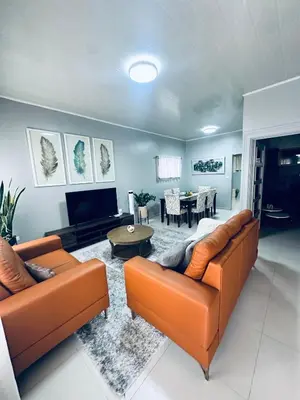 a living room with two orange couches and a table at Venus Home in Guápiles