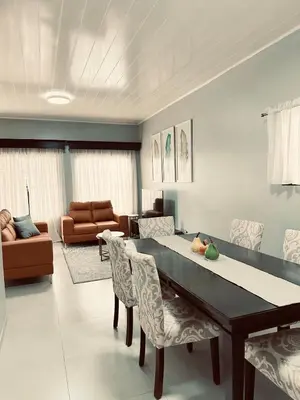 a living room with a dining table and chairs at Venus Home in Guápiles