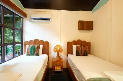 a room with two beds and a window at Coco Cabana in the Jungle in Sarapiquí