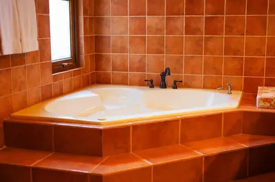 a bath tub in a tiled bathroom with a window at Palacio Tropical- Secluded & Private Beach in Puntarenas