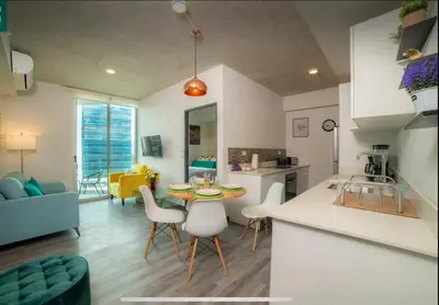 a kitchen and living room with a table and chairs at Dreamliner at 11s, City Views and Wonderland Vibes! in Hatillo