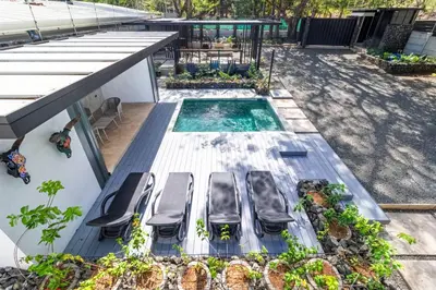 a deck with chairs and a swimming pool at Z102 Studios, 4 Industrial Beach Condos w Pool! in Playa Flamingo