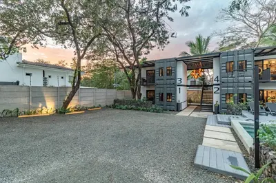 an exterior view of a house with a driveway at Z102 Studios, 4 Industrial Beach Condos w Pool! in Playa Flamingo