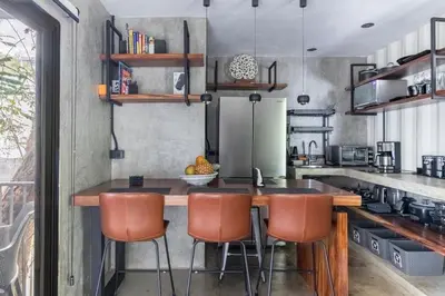 a kitchen with a wooden table and chairs at Z102 Studios, 4 Industrial Beach Condos w Pool! in Playa Flamingo