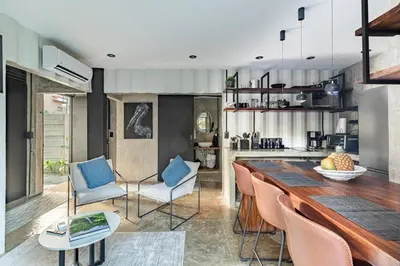 a kitchen and dining room with a long table and chairs at Z102 Studios, 4 Industrial Beach Condos w Pool! in Playa Flamingo