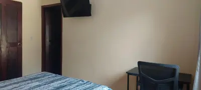 a bedroom with a bed and a chair and a television at Capi-Capi Retreat in Paquera