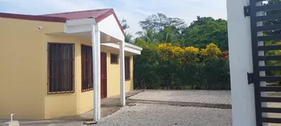 a yellow house with a gate and a building at Capi-Capi Retreat in Paquera