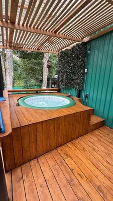 a hot tub in a wooden deck with a pergola at Cabaña Vacal Wifi, beach front #2 in Uvita