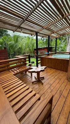 a wooden deck with benches and a table and a pool at Cabaña Vacal Wifi, beach front #2 in Uvita