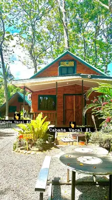 a small house with a bench in front of it at Cabaña Vacal Wifi, beach front #2 in Uvita