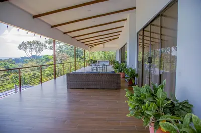 a room with a balcony with tables and plants at Home in Perez Zeledon with Chirripó Views in Angostura