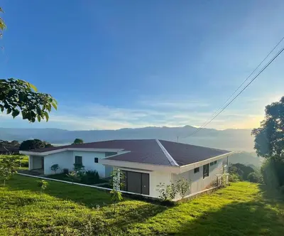 a white house on a hill with a view at Home in Perez Zeledon with Chirripó Views in Angostura