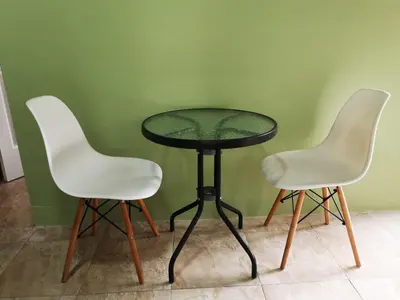 two white chairs and a table with a glass top at Casa Tucan in Aguas Zarcas
