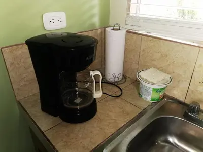 a coffee maker sitting on a counter next to a sink at Casa Tucan in Aguas Zarcas