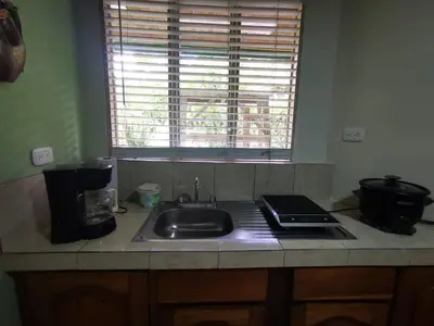 a kitchen counter with a sink and a window at Casa Tucan in Aguas Zarcas