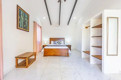 a bedroom with a bed and a book shelf at Casa Paraiso de Ballenas in Uvita