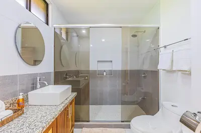 a bathroom with a shower and a toilet and a sink at Casa Paraiso de Ballenas in Uvita