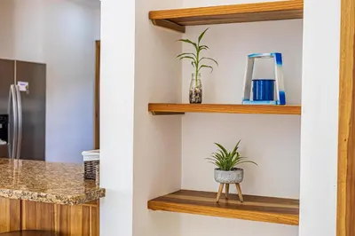 a bathroom with wooden shelves and a plant at Casa Paraiso de Ballenas in Uvita