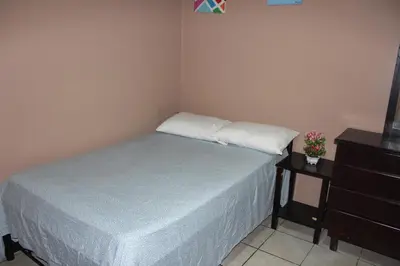 a small bedroom with a bed and a dresser at Hotel El Dorado in San José