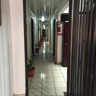 an empty hallway with potted plants in a building at Hotel El Dorado in San José