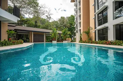 a swimming pool in the middle of a building at Torres del Mar oceanview 6th-floor two-bedroom condo in Jacó
