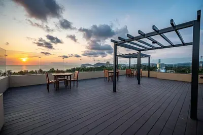 a deck with tables and chairs on top of a building at Torres del Mar oceanview 6th-floor two-bedroom condo in Jacó