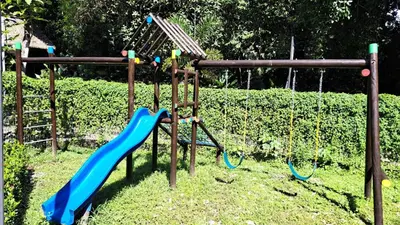 a playground with two swings and a slide at Torres del Mar oceanview 6th-floor two-bedroom condo in Jacó