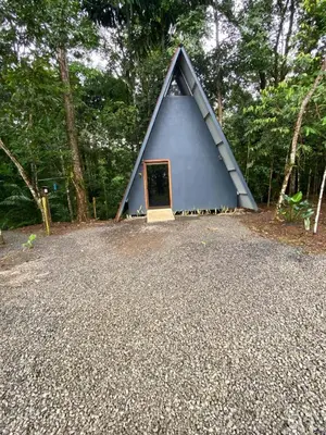 a small blue house with a door in the middle at El Nido del Tucan Rio Celeste in El Achiote