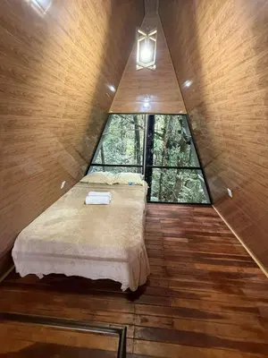 a bed in a room with a large window at El Nido del Tucan Rio Celeste in El Achiote