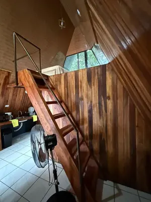 a wooden staircase in a room with a window at El Nido del Tucan Rio Celeste in El Achiote