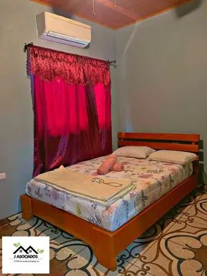 a bedroom with a bed with a red window at Casa SAMY in Uvita