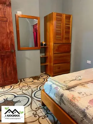 a bedroom with a bed and a dresser and a mirror at Casa SAMY in Uvita