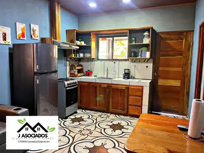 a kitchen with wooden cabinets and a stove top oven at Casa SAMY in Uvita