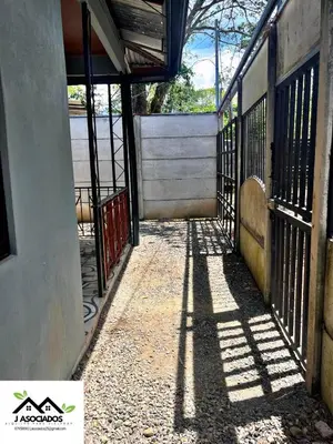 a hallway of a building with a gate and its shadow at Casa SAMY in Uvita