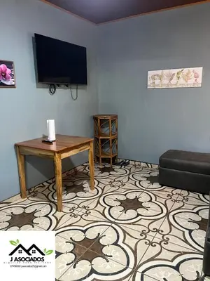 a living room with a tv and a table and a couch at Casa SAMY in Uvita