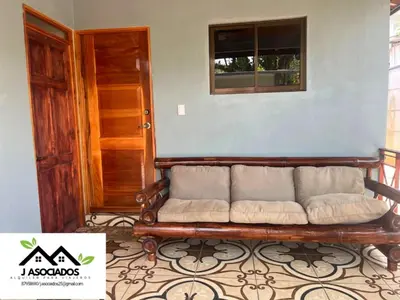 a couch sitting in a room with a window at Casa SAMY in Uvita