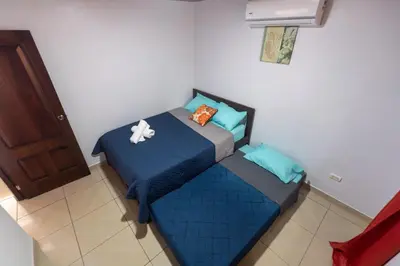 a small bedroom with a blue bed in a room at Villa Jade La Fortuna, Family in Fortuna