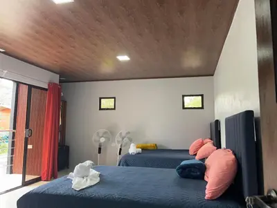 a bedroom with two beds and a wooden ceiling at Villa Jade La Fortuna, Family in Fortuna