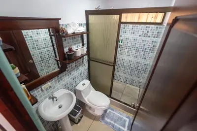 a bathroom with a toilet and a sink and a shower at Villa Jade La Fortuna, Family in Fortuna