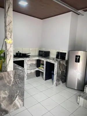a kitchen with marble counter tops and a stainless steel refrigerator at Villa Jade La Fortuna, Family in Fortuna