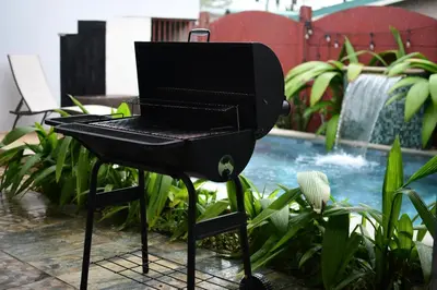 a grill with a laptop on it in a garden at Villa Jade La Fortuna, Family in Fortuna